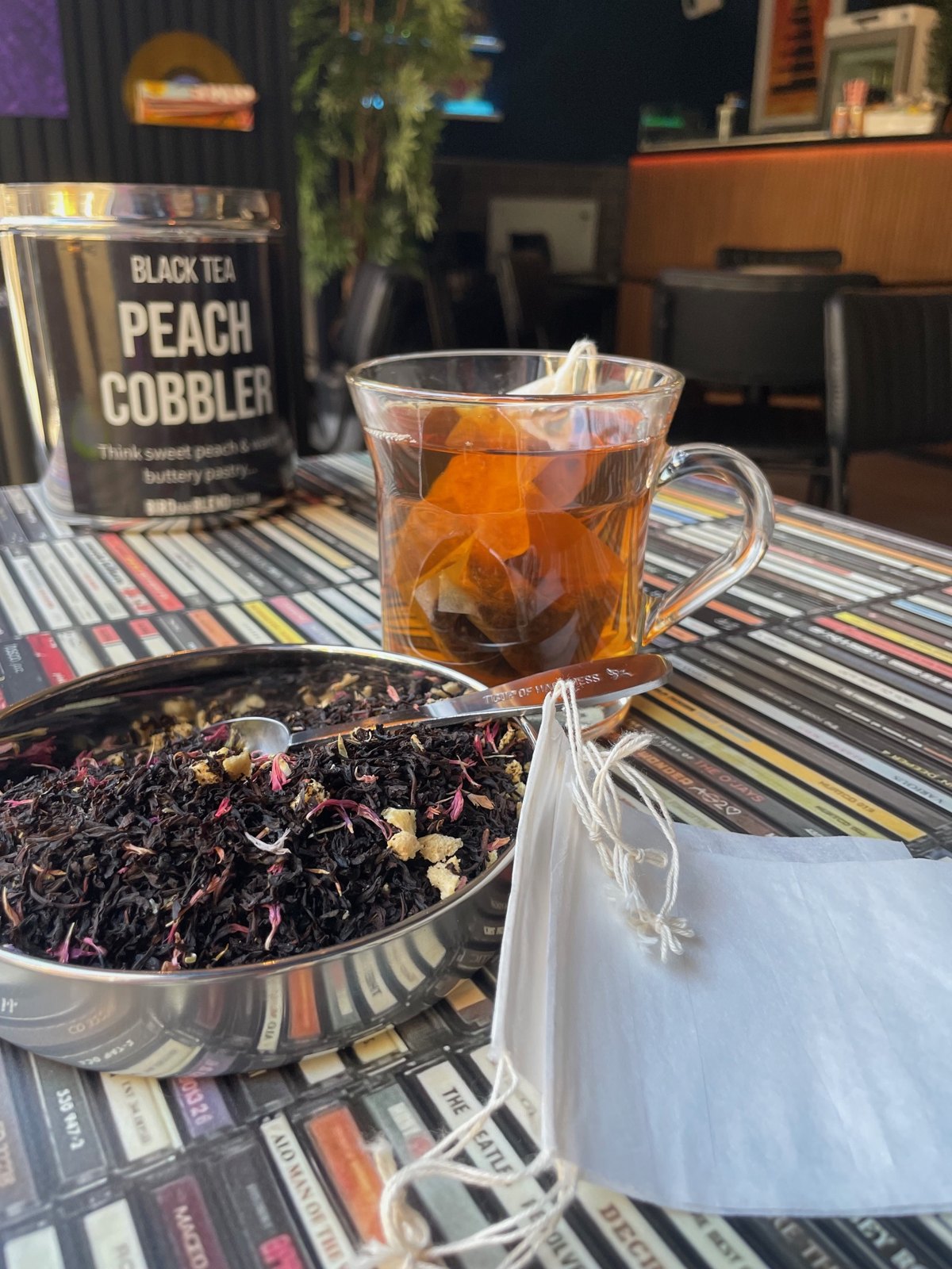 A glass of freshly brewed peach cobbler black tea on a record-sleeve table