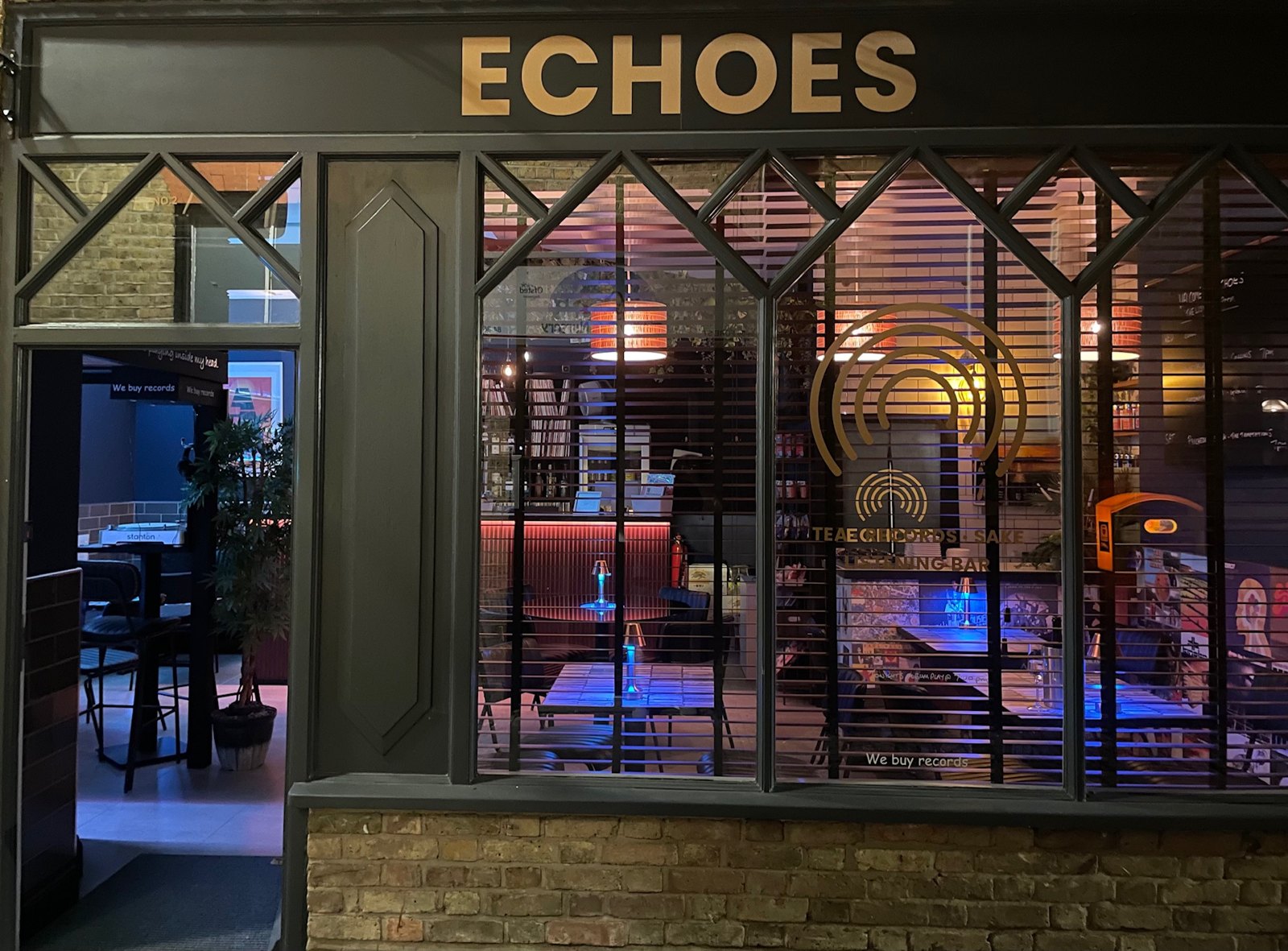 The Echoes shopfront in Hertford lit up at night