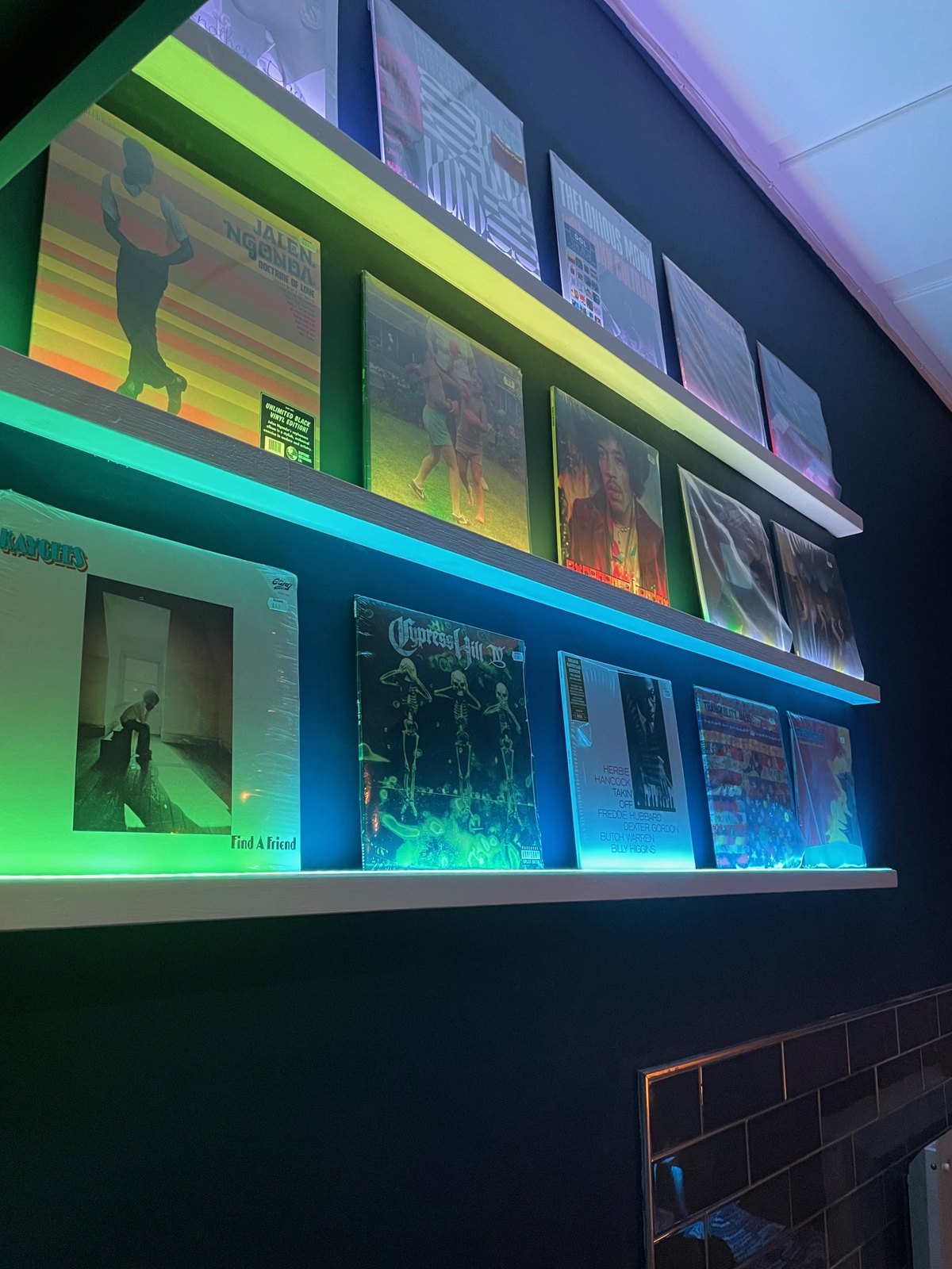 Record sleeves displayed on lit shelves at Echoes